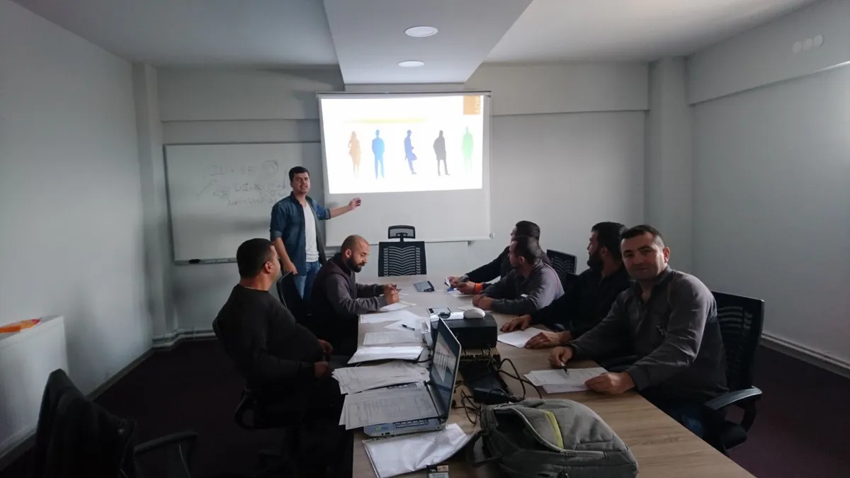 Eğitim salonunda sunum yapan eğitmen ve katılımcılar